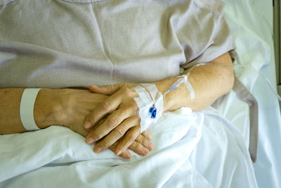 Close-up of woman with hand on bed