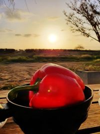 Close-up of red drink against sky at sunset