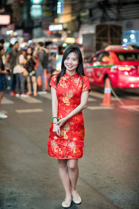 Full length portrait of woman standing on street