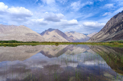 Scenic view of lake and mountains against sky