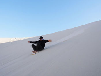 Full length of young man in desert against clear sky