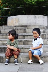 Full length of a boy sitting outdoors