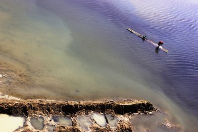 High angle view of people on wooden raft in sea