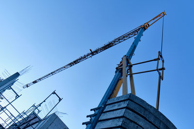 Low angle view of crane against clear sky