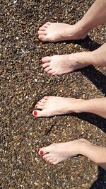 Low section of woman standing on pebbles