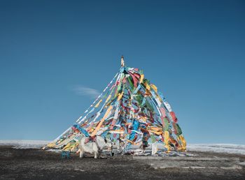 Low angle view of traditional windmill on beach against clear sky