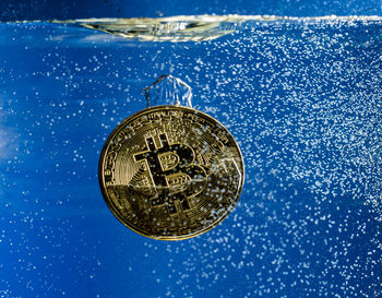 Close-up of coin against blue sky
