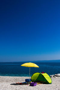 Scenic view of beach against clear blue sky