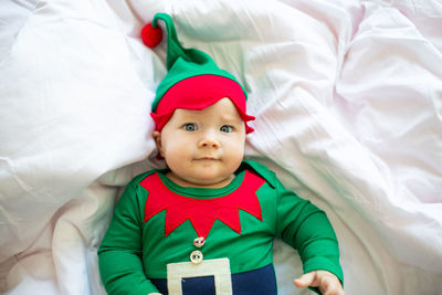 Portrait of cute baby girl lying down on bed