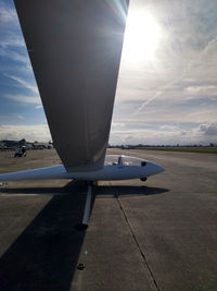 Close-up of airplane on airport runway against sky