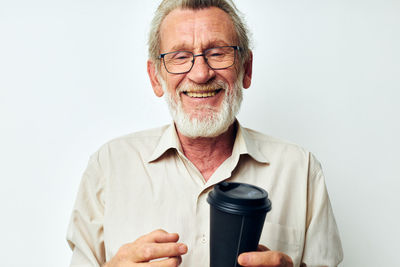 Portrait of young man holding trophy against white background