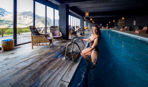 Side view of mid adult woman in swimming pool at tourist resort