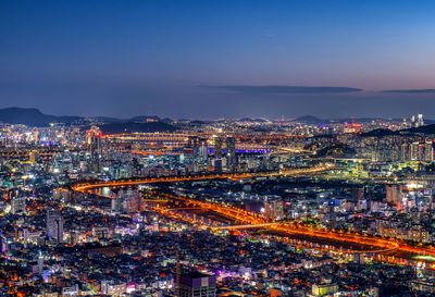 High angle view of city lit up at night