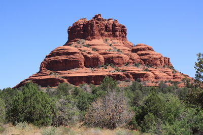 Low angle view of rocky mountains against blue sky