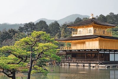 Building by lake against sky