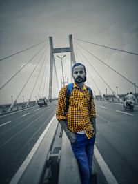 Man standing on bridge against sky