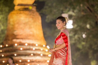 Side view of a smiling young woman standing outdoors