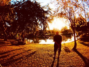 Rear view of man walking in park during autumn