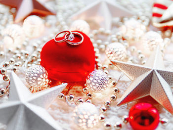 Christmas and new year decorations. red heart gift box with wedding diamond rings.