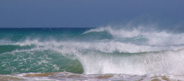 Close-up of waves splashing on sea against sky