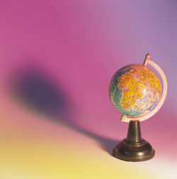 Close-up of globe against colored background