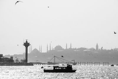 Boats in sea with buildings in background