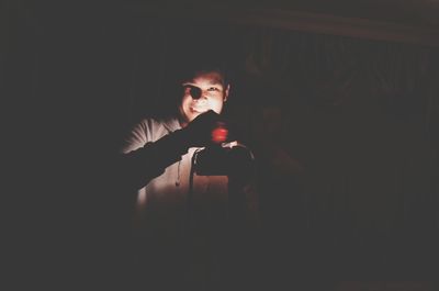 Portrait of young man standing in darkroom