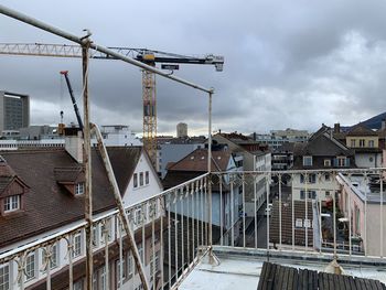 Construction site by buildings against sky