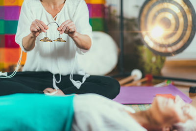 Midsection of woman playing musical instrument for customer in spa