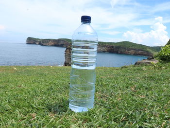 Water bottle by sea against sky