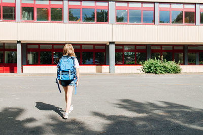 Happy girl schoolgirl with a backpack on her back goes to school. start the new school year. 