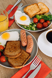 English breakfast with cup of black coffee and orange juice, grilled sausage