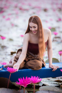 Beautiful young woman with pink flower