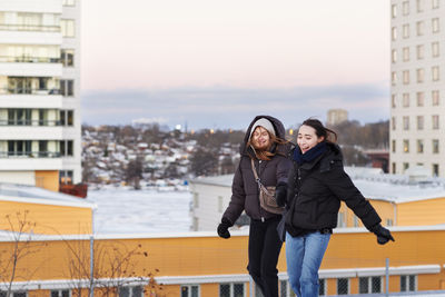 Female couple holding hands in modern neighborhood