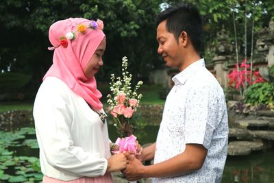 Side view of a woman holding flower bouquet