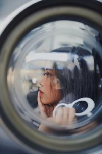 Reflection of woman photographing in camera