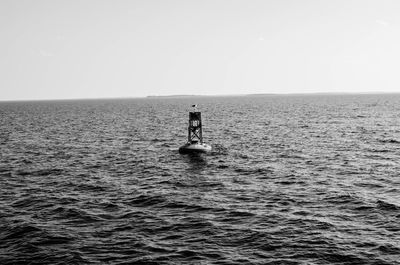 Man standing in sea against clear sky
