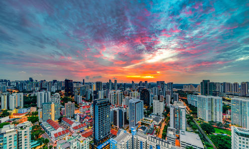 Aerial view of city buildings against sky during sunset