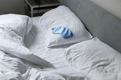 Sleep mask on pillow on bed, sleep concept