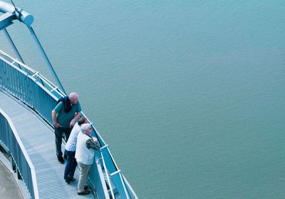 High angle view of people walking on bridge over sea