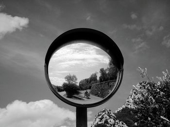 Low angle view of mother with children reflecting on road mirror