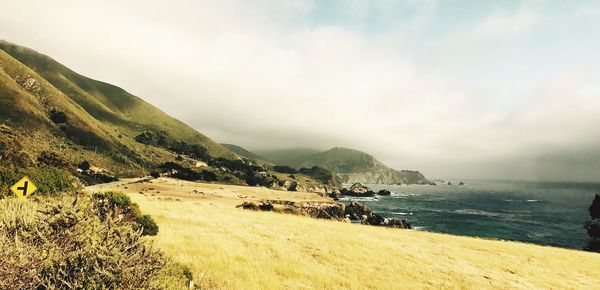 Scenic view of sea and mountains against sky