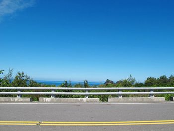 Road against clear blue sky