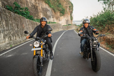 Man riding motor scooter on road