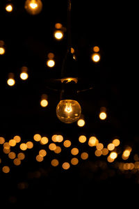 Low angle view of illuminated light bulbs