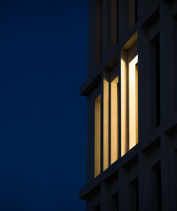 Low angle view of illuminated building against blue sky