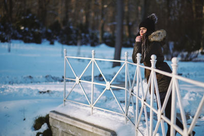 Woman leaning on railing during winter