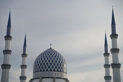 Communications tower in city against sky