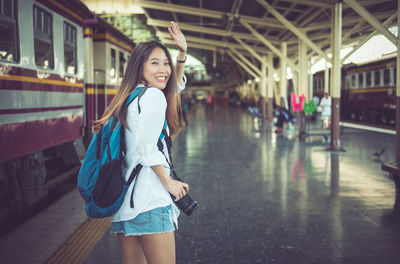 Portrait of young woman standing in city