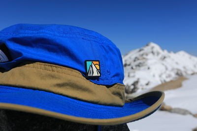 Close-up of snow covered mountain against blue sky